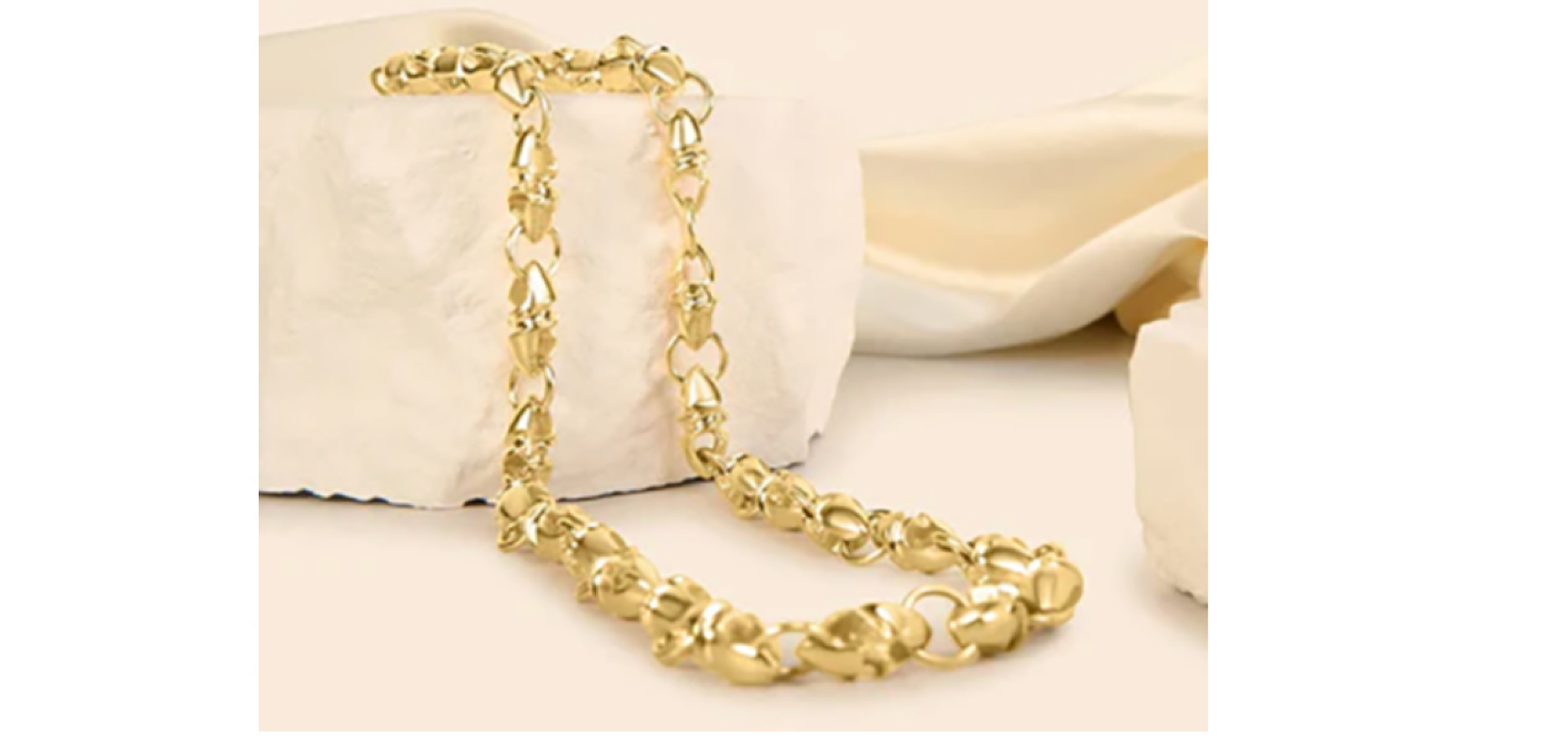 A young man in a white t-shirt wearing a gold oval link necklace by Sziro Jewelry in Coral Springs 